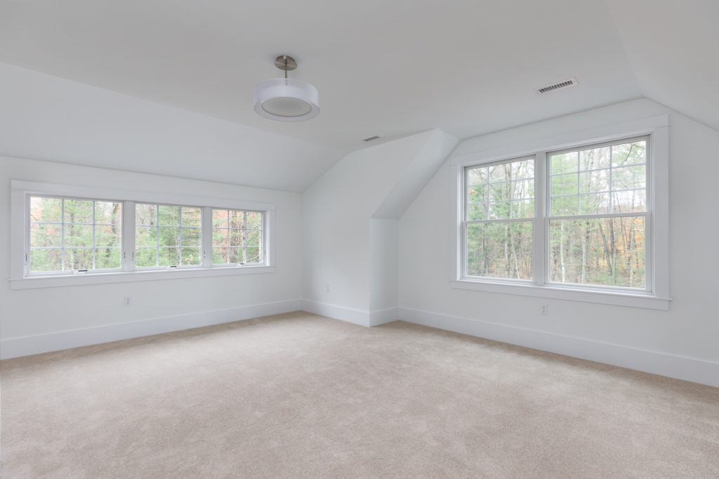 An unfurnished room with light beige carpeting and white walls 